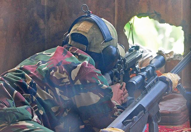 An Army sniper lies on a prone position as he tries to find a target in Marawi City. Photo by Froilan Gallardo[1]